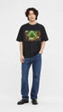 Model wearing HUGFAB black comic graphic oversized T-shirt with blue jeans on white background