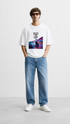 HUGFAB Chase the Rush white oversized graphic T-shirt worn by male model with light blue jeans and white sneakers
