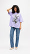 Model wearing HUGFAB lavender snake graphic oversized T-shirt with blue jeans on white background