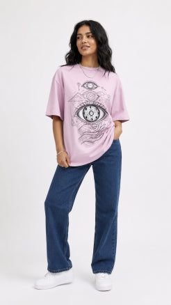 Model wearing HUGFAB pink eye graphic oversized T-shirt with blue jeans on white background