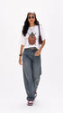 Model wearing HUGFAB white beetle graphic oversized T-shirt with baggy jeans on white background